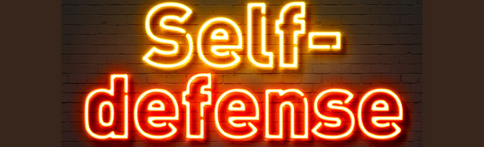 lit up neon sign that says self-defense