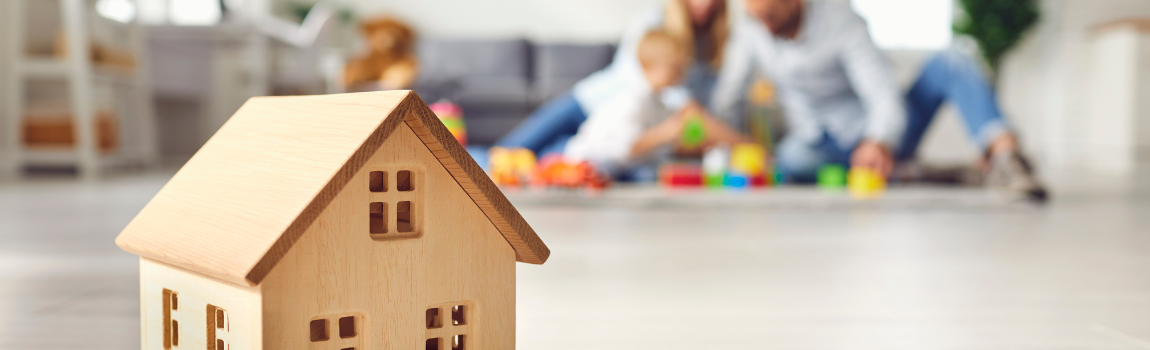 wood model home with family in background